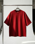 Red t-shirt on a hanger against a white background