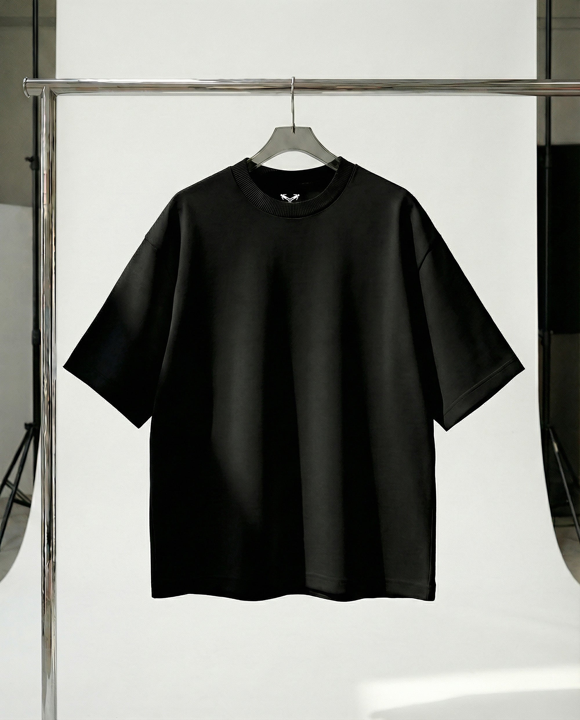 Black t-shirt on a hanger against a white background