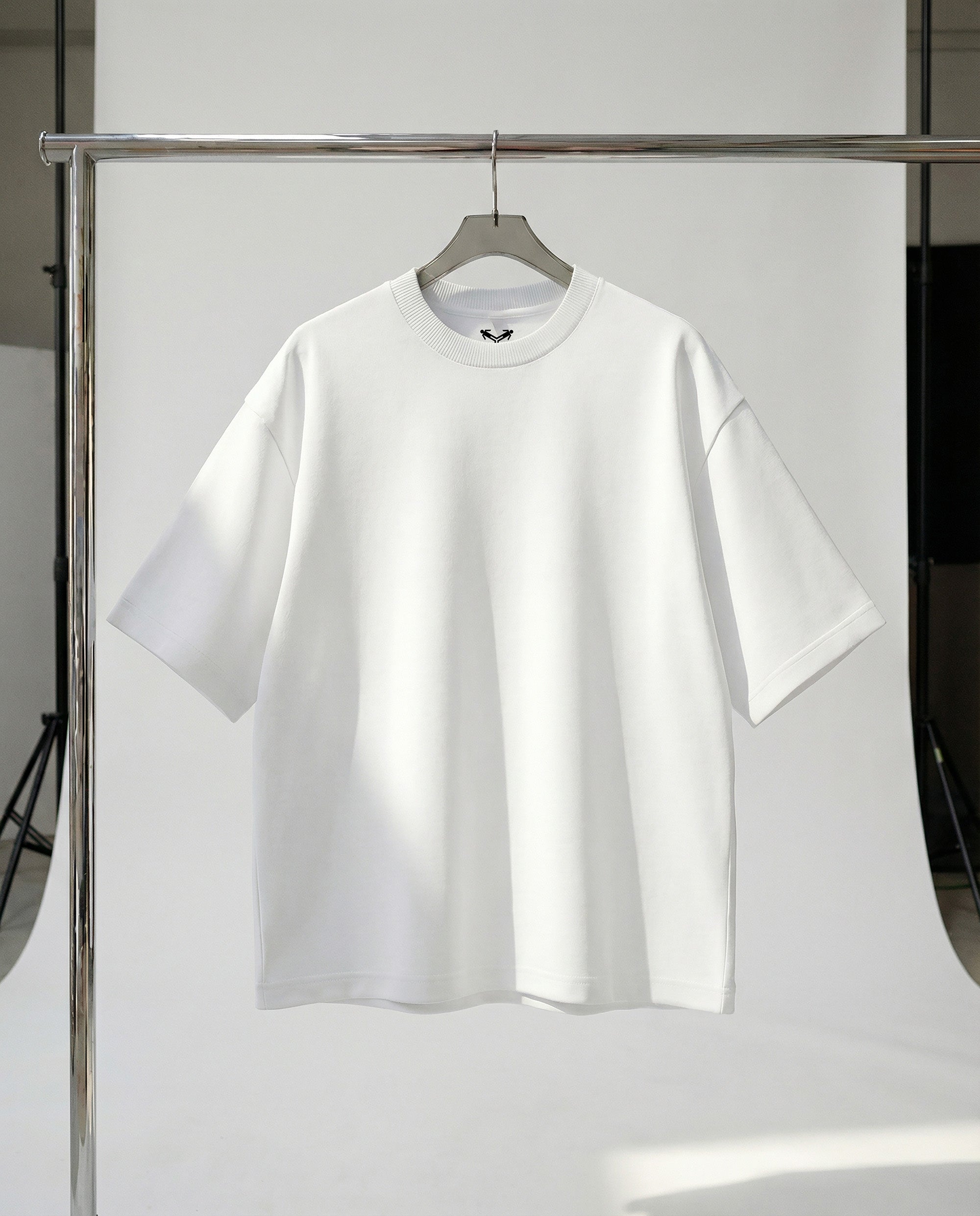 White t-shirt on a hanger against a white background