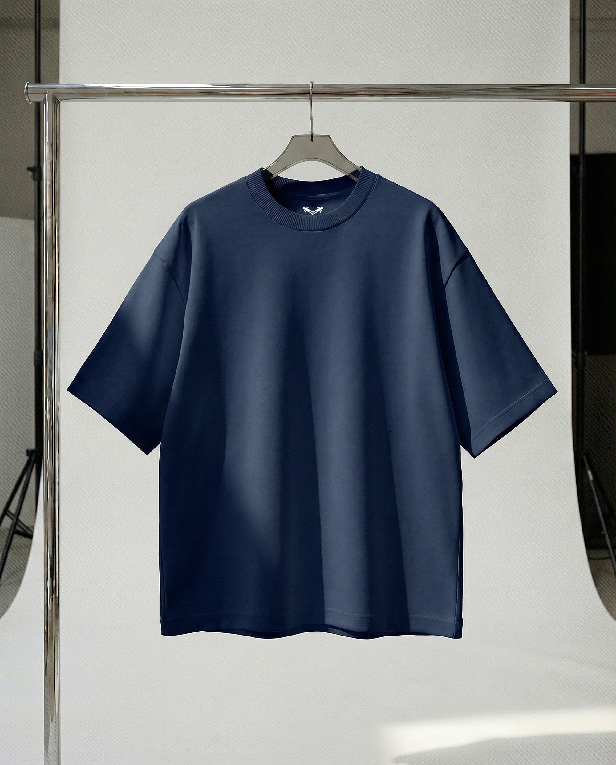 Navy blue t-shirt on a hanger against a white background