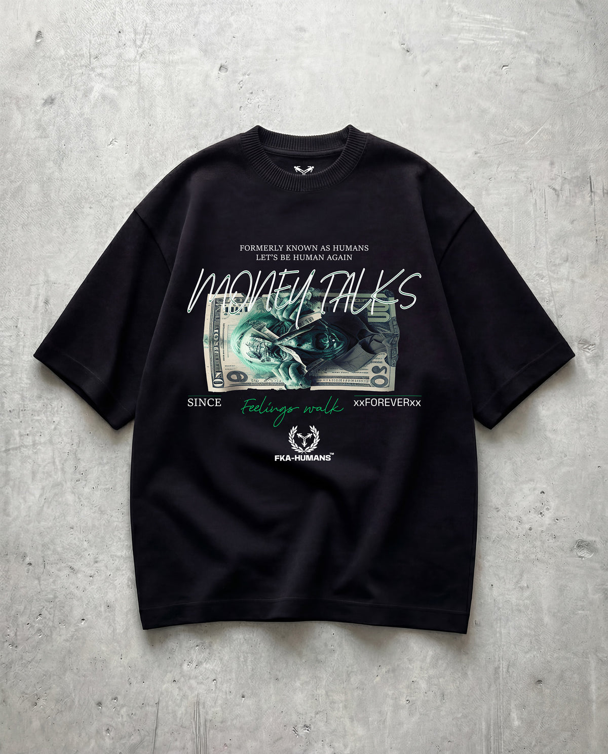 Black t-shirt with graphic design and text on a gray concrete surface